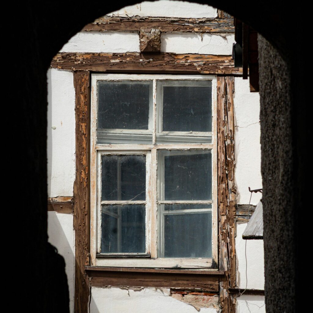 Old damaged wood window frame with peeling paint